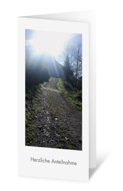 Illustration einer hochformatigen Trauerkarte mit einem Bergweg im Sonnenlicht